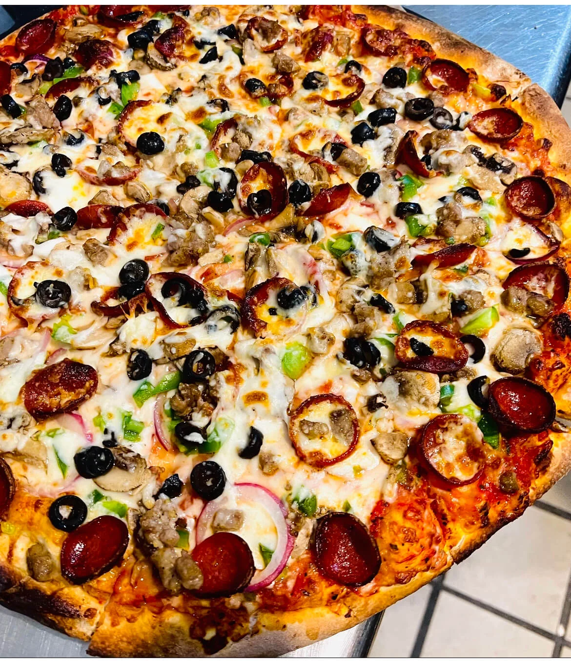 A Scuola specialty pie with pepperoni, olives and peppers